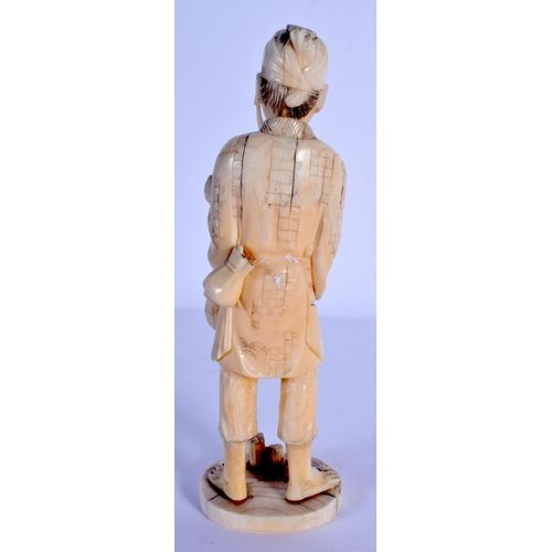 1693 - A LATE 19TH CENTURY JAPANESE MEIJI PERIOD CARVED IVORY OKIMONO modelled holding a trident. 18 cm hig... 