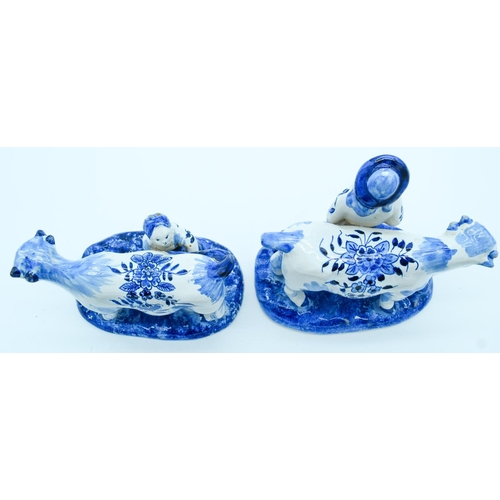 4145 - Two Delft pottery figures of Cows and farm hands 13 x 16 cm (2).