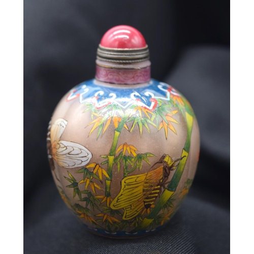 4225 - A Chinese glass snuff bottle decorated with insects and foliage 7 cm .