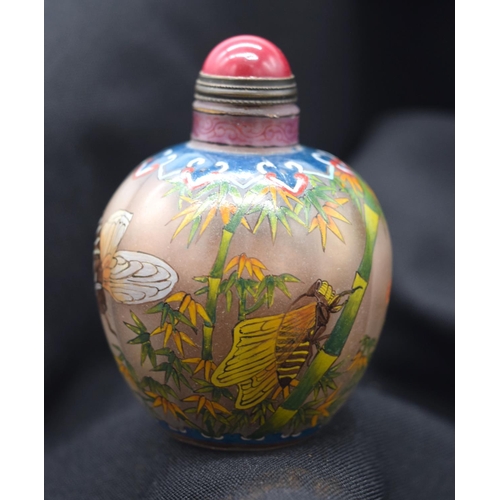 4225 - A Chinese glass snuff bottle decorated with insects and foliage 7 cm .