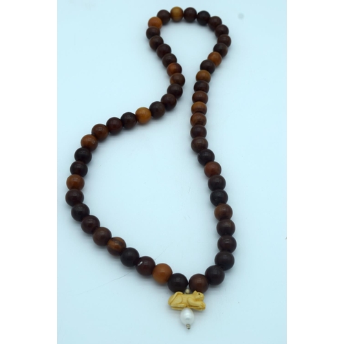 4276 - A Horn necklace with an Ivory and pearl pendant 80cm