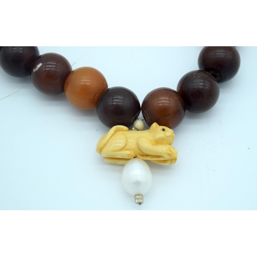 4276 - A Horn necklace with an Ivory and pearl pendant 80cm