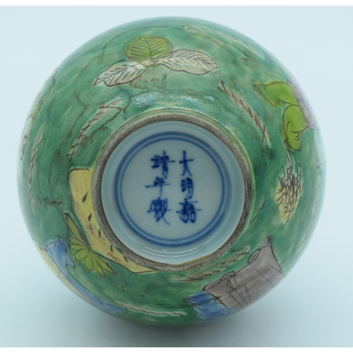 4435 - A Chinese green glaze vase decorated with kite flyers 19cm.