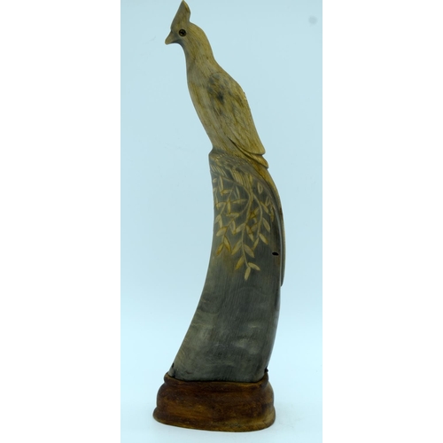 4467 - A carved horn bird on a wooden stand 28cm.