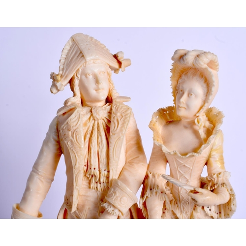 724 - A FINE 19TH CENTURY EUROPEAN DIEPPE IVORY FIGURE OF A DANDY modelled with a female, upon a wooden pl... 