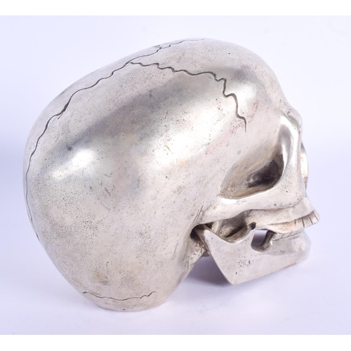 770 - A CONTEMPORARY SILVER PLATED SKULL. 11 cm x 9 cm.