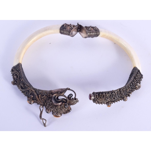 790 - A RARE 19TH CENTURY INDIAN SILVER AND BONE BUDDHISTIC BANGLE. 20 cm long extended.