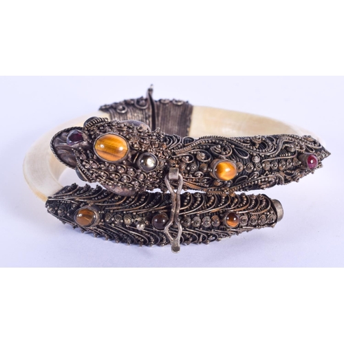 790 - A RARE 19TH CENTURY INDIAN SILVER AND BONE BUDDHISTIC BANGLE. 20 cm long extended.