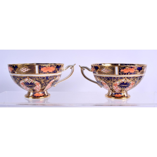 145 - Royal Crown Derby imari  pattern 1128  two pedestal cups and saucers.  Cup 5.5cm high, Saucer 14cm w... 