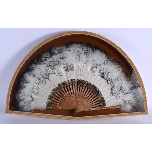 324 - A 1920S FRAMED FEATHER FAN with a painted wood stems. Fan 55 cm wide.