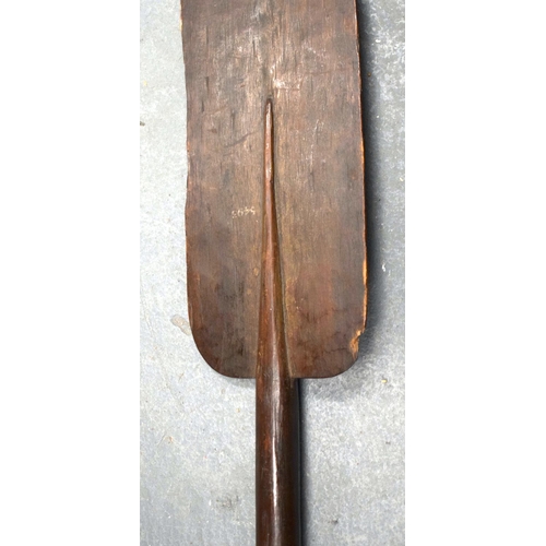 354 - A 19TH CENTURY AFRICAN TRIBAL CARVED WOOD PADDLE together with another similar. 155 cm long. (2)