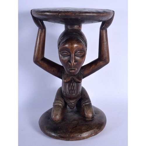 402 - A LARGE AFRICAN TRIBAL CARVED WOOD FERTILITY STOOL modelled upon a circular base. 43 cm x 23 cm.