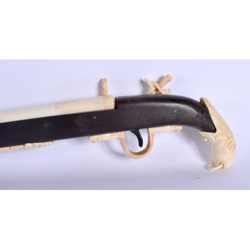 436 - A LARGE CONTINENTAL CARVED BONE RIFLE with lion mask head terminal. 90 cm long.