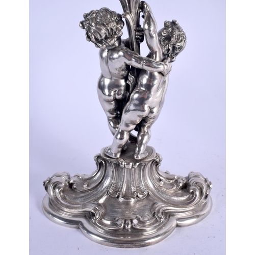 1157 - A LOVELY PAIR OF CONTINENTAL SILVER CANDLEABRA modelled two cherubs holding aloft floral capped scon... 