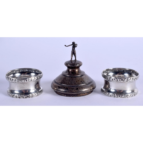 1179 - TWO ANTIQUE SILVER NAPKIN RINGS and a golfing silver lid. 56 grams. Largest 7 cm x 6 cm. (3)