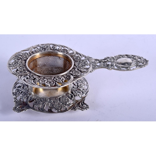 1235 - A 19TH CENTURY CONTINENTAL SILVER TEA STRAINER ON STAND. 87 grams. 12 cm x 7 cm. (2)