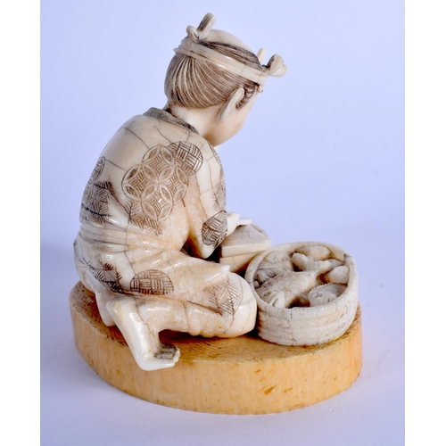 1521 - A 19TH CENTURY JAPANESE MEIJI PERIOD CARVED IVORY FIGURE OF A MALE modelled preparing fish. 8 cm x 9... 