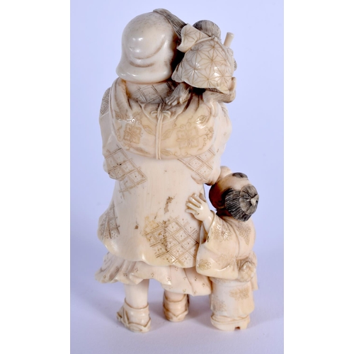 1717 - A 19TH CENTURY JAPANESE MEIJI PERIOD CARVED IVORY OKIMONO modelled as a male beside a child. 10 cm x... 