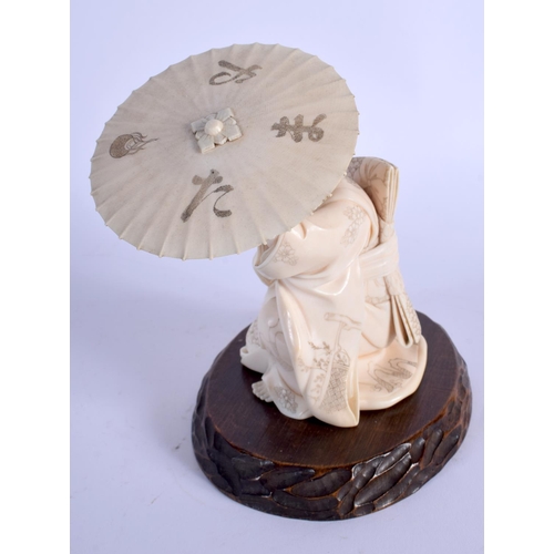 1729 - A FINE 19TH CENTURY JAPANESE MEIJI PERIOD CARVED IVORY OKIMONO modelled as a female sheltering under... 