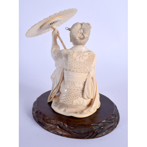 1729 - A FINE 19TH CENTURY JAPANESE MEIJI PERIOD CARVED IVORY OKIMONO modelled as a female sheltering under... 