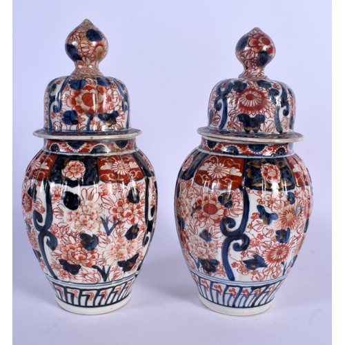 1734 - A PAIR OF 19TH CENTURY JAPANESE MEIJI PERIOD IMARI VASES AND COVERS of ribbed form. 30 cm high.