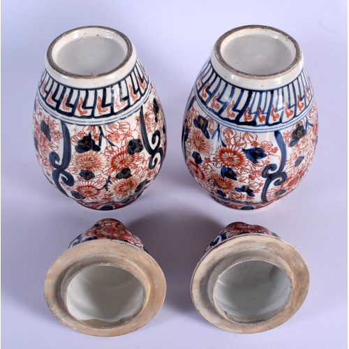 1734 - A PAIR OF 19TH CENTURY JAPANESE MEIJI PERIOD IMARI VASES AND COVERS of ribbed form. 30 cm high.