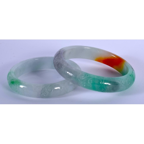 1765 - TWO CHINESE CARVED JADEITE BANGLES 20th Century. 8 cm diameter. (2)