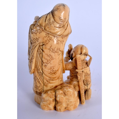 1824 - A 19TH CENTURY JAPANESE MEIJI PERIOD CARVED IVORY OKIMONO modelled as a scholar beside a male. 9 cm ... 