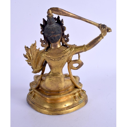 2074 - A CHINESE SINO TIBETAN GILT BRONZE FIGURE OF A BUDDHISTIC DEITY modelled upon a triangular base. 19 ... 