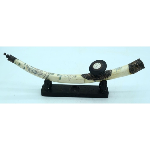 2570 - Chinese engraved bone opium pipe with a hardwood stand. 42cm.