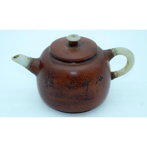 2607 - A Chinese Yixing tea pot with a mounted Jade handle and spout. 10 x 17cm.