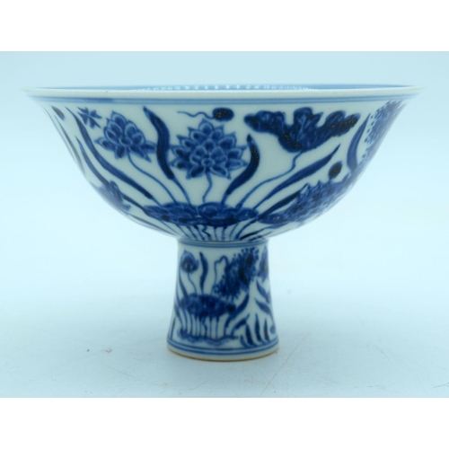 2640 - A Chinese blue and white stem cup decorated with fish. 16 x 10cm.