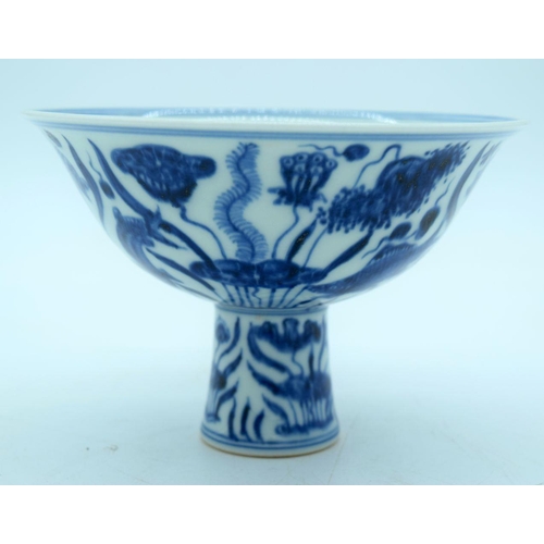 2640 - A Chinese blue and white stem cup decorated with fish. 16 x 10cm.