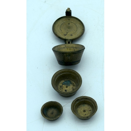 2657 - A small bronze set of graduated weights together with two other bronze items. 7cm (3)