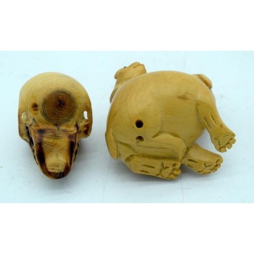 2658 - A carved wooden Netsuke inn the form of a dog and a carved wooden skull 4cm (2)