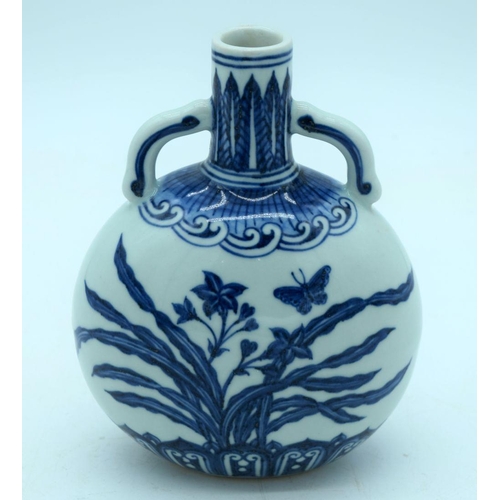 2670 - A small Chinese  blue and white moon flask decorated with butterfly and  foliage. 19cm.