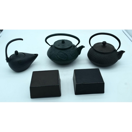 2680 - Three heavy cast iron  metal Japanese tea pots together with two boxes . 18 x 9 cm (5).