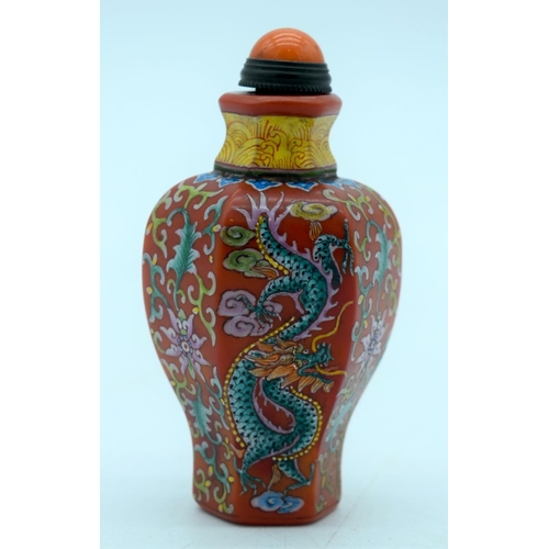 2695 - A Chinese red ground snuff bottle with a dragon and foliage. 9cm.