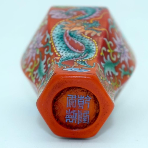 2695 - A Chinese red ground snuff bottle with a dragon and foliage. 9cm.