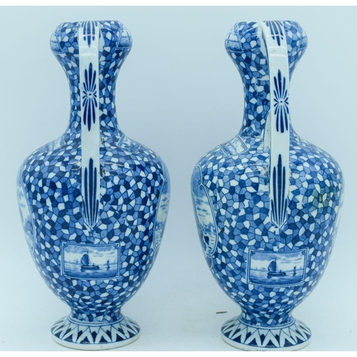 2822 - A pair of Delft twin handle vases painted with scenes of Dutch barges. 25cm.