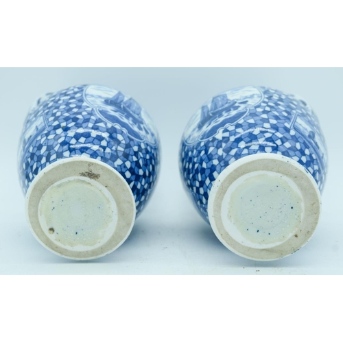 2822 - A pair of Delft twin handle vases painted with scenes of Dutch barges. 25cm.