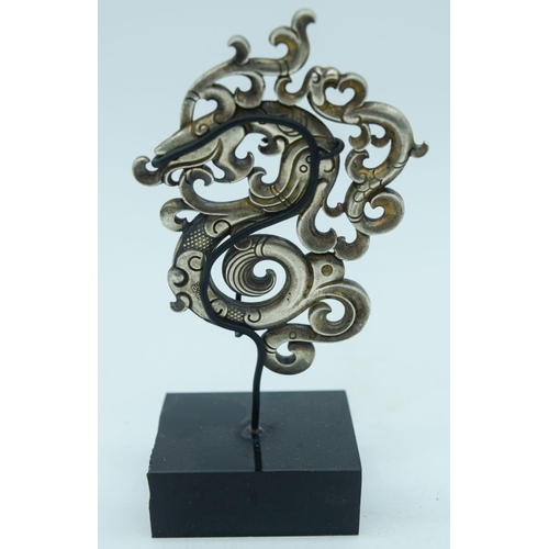 2840 - A Chinese white metal dragon plaque on a stand 8cm.