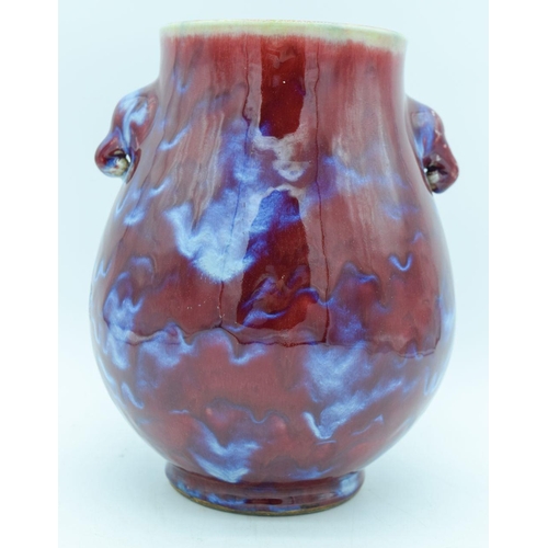 2945 - A Chinese Flambe glazed vase with elephant head handles 27cm.