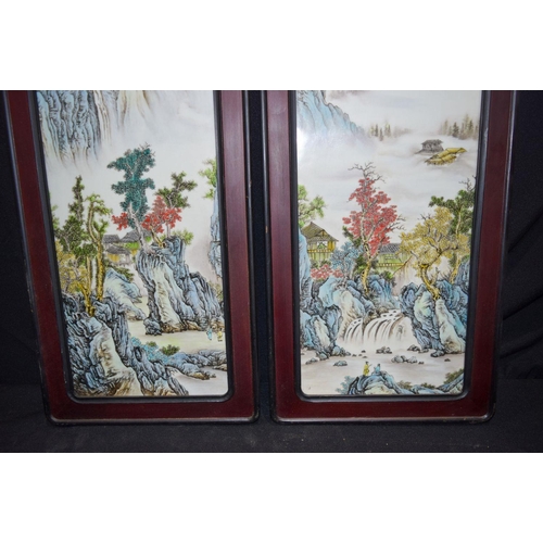 3005 - A pair of Hongmu framed Chinese porcelain panels decorated with a Famille verte landscape 82 x 29cm ... 