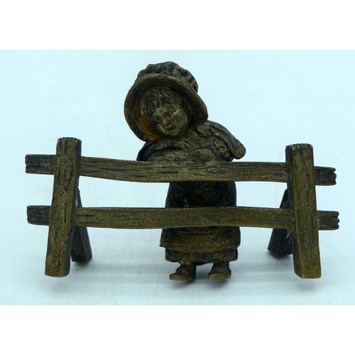 2926 - A small gilt bronze figure of a girl leaning on a fence 10 x 7cm.