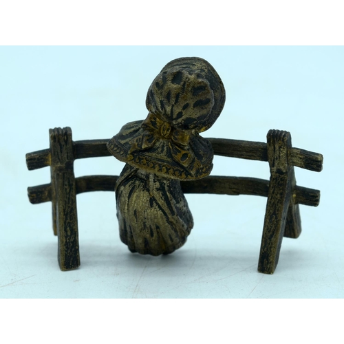 2926 - A small gilt bronze figure of a girl leaning on a fence 10 x 7cm.