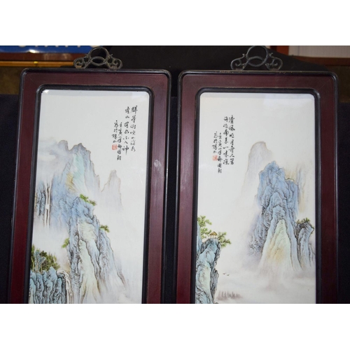 3005 - A pair of Hongmu framed Chinese porcelain panels decorated with a Famille verte landscape 82 x 29cm ... 