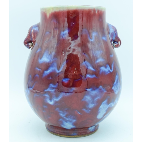 2945 - A Chinese Flambe glazed vase with elephant head handles 27cm.