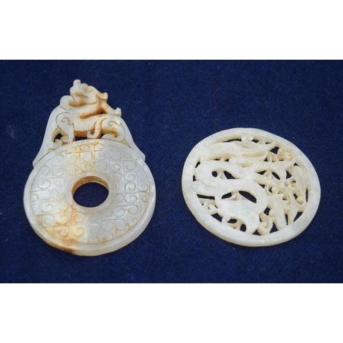 2963 - Two Jade pendants decorated with a dragon and a lion 8.5cm.