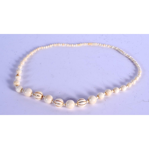 911 - A 1920S EUROPEAN GOLD AND IVORY NECKLACE. 54 cm long.